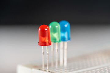 Focus on Red LED next to green and blue diodes stuck in electric scientific exploration kit...