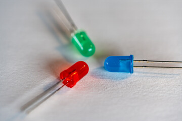 Red Green Blue LED parts facing each other macro shot on white background