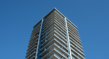 Fototapeta premium Modern Apartment Building Against a Clear Blue Sky