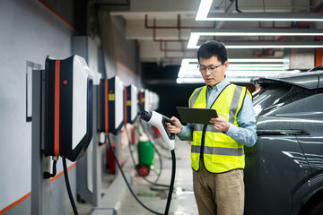 asian Male engineer working with digital tablet in charging station