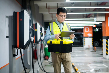 asian Male engineer working with digital tablet in charging station