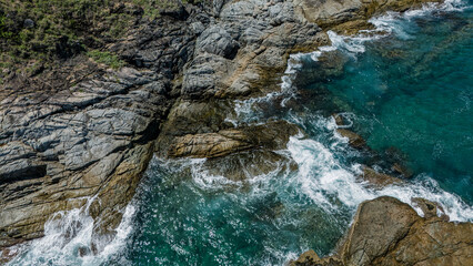 Rocky shoreline where the waves are dramatically crashing against the rocks and stones