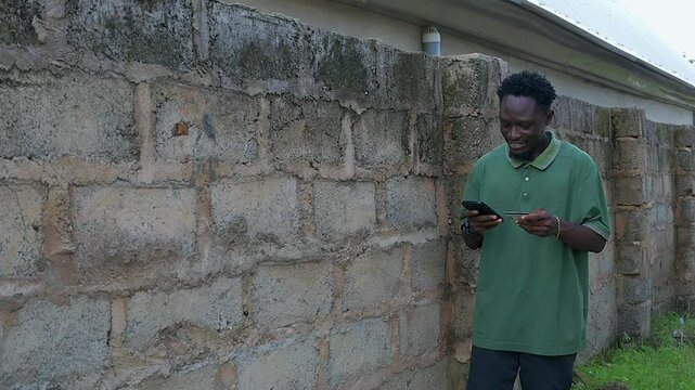 copy space of man standing smile using mobile phone and credit card 