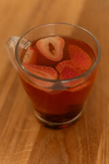 Strawberry tea with sliced strawberries in a clear glass