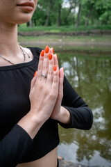 A calm, harmonious scene: young woman outdoors in a prayer pose. Yoga, breathing practice,...