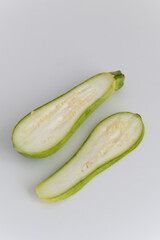 Halved Zucchini on White Background showing its inner structure and texture.