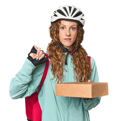 Redhead food delivery in studio showing a dislike gesture, thumbs down. Disagreement concept.