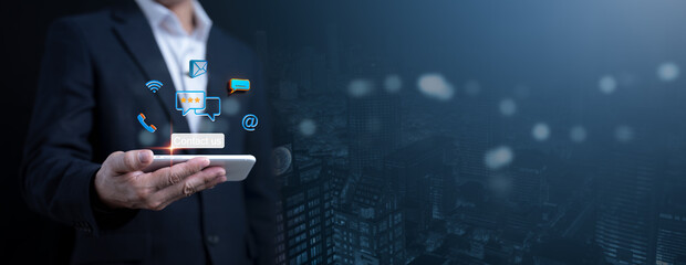 Digital connectivity and communication concept with a businessman holding a smartphone, surrounded by glowing icons for messaging, email, call, and social media.