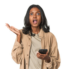 Young Indian woman using a smartphone surprised and shocked.