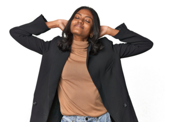 Young Indian woman in business suit feeling confident, with hands behind the head.