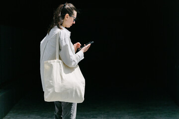 Woman walking in the city with a white tote eco bag