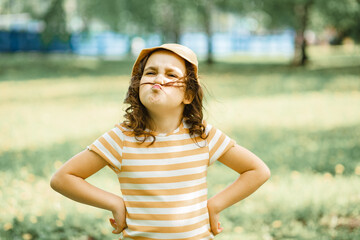 Cute little girl making fake mustache with hair outdoor on nature