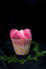 Traditional pink steamed sponge cake with soft texture on black cloth and leaf decoration on dark background, suitable for advertising or promotion.