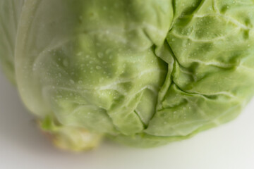 Close-up of a fresh green cabbage on a white background.