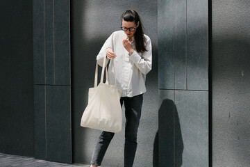 Woman walking in the city with a white tote eco bag