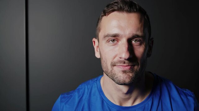 Man in blue shirt. Man is sitting indoors wearing blue shirt. A casual male with a neutral background. A guy wearing a blue shirt lifestyle.