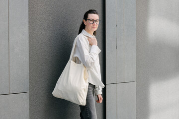 Woman walking in the city with a white tote eco bag