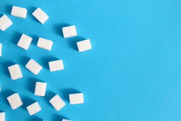 There are a lot of sugar cubes on a blue background.