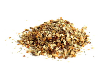  There is a small pile of dry herbal seasonings on a white background