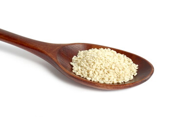  On a white background lies a wooden spoon with sesame seeds.	