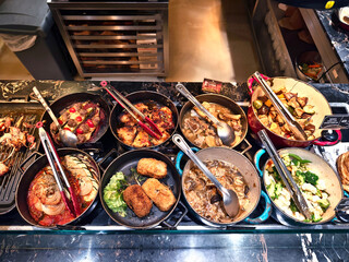 A large and diverse buffet that includes a wide variety of different types of delicious food.