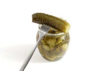There is a glass jar with pickled cucumbers on a white background.