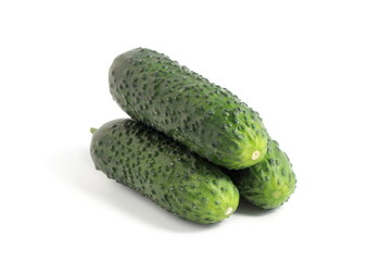 Three fresh green cucumbers lie on a white background.
