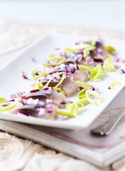 Sliced salted herring with leek and spices. Bright background. 