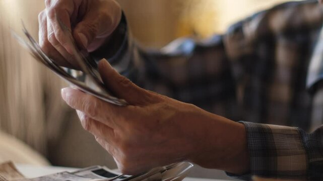 close-up in the hands of an elderly man old black and white family photos, a pensioner looks at a family photo archive