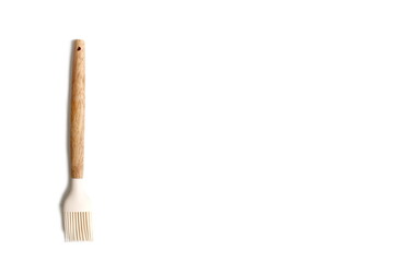 On a white background lies a brush for greasing a frying pan with oil.	