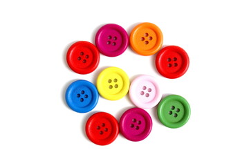 There are many multi-colored buttons on a white background.	