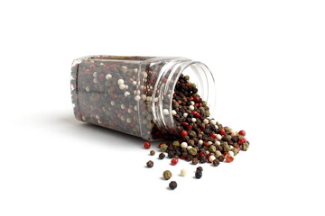 An assortment of hot peppers spilled out of a transparent container.	