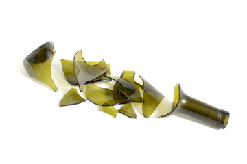 There is a broken green wine bottle lying on a white background.