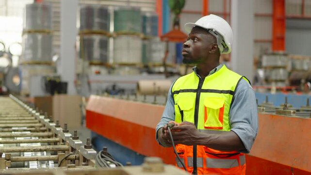 Worker or engineer operating remote switch to control machine in the factory