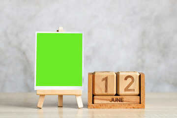 Green screen canvas and wooden calendar showing june 12th for design mockup