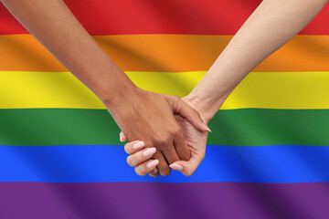 Interracial women couple holding hands closeup. Symbol of LGBTQ pride, love, racial diversity,...