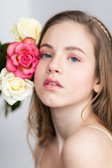 Little pretty girl in pink holds the bouquet of roses.