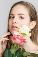 Little pretty girl in pink holds the bouquet of roses.