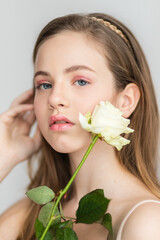 Little pretty girl in pink holds the bouquet of roses.