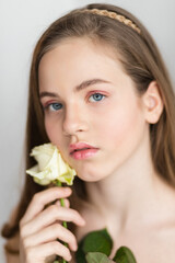 Little pretty girl in pink holds the bouquet of roses.