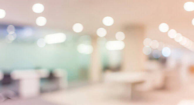Intentionally blurred office interior with symmetrical rows of desks and glowing ceiling lights for background or layout filler use.