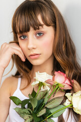 Little pretty girl in pink holds the bouquet of roses.