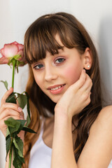 Little pretty girl in pink holds the bouquet of roses.