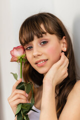 Little pretty girl in pink holds the bouquet of roses.