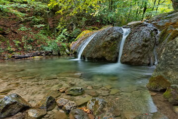 Russia, Republic of Crimea. View of the waterfall on the Ulu-Uzen River in the shade of the rocky thickets of the mountain gorge of the Haphal Hydrological Reserve.