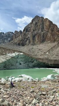 A glacier in the mountains. Kyrgyzstan, Ala Archa National Park. Uchitel glacier. Ice blocks lying in icy water, Glacier melting, glaciers disappearing, global warming, Switzerland, Tien Shan