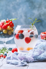 Detox fruit infused flavored water with ice. Refreshing summer homemade cocktail with berries