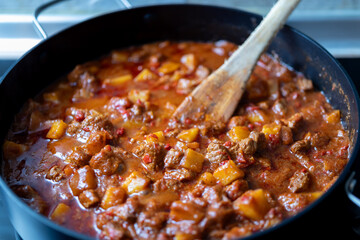 traditional hungarian goulash with beef and potatoes, hearty stew cooking in a pot