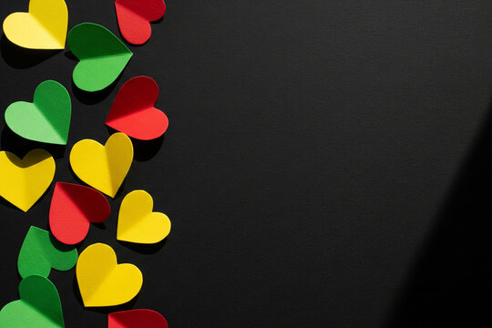 photo of handcrafted paper hearts in red, yellow, and green celebration for juneteenth