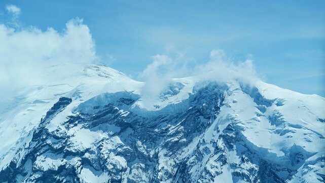 Snow-Capped mountain Peak with Drifting Clouds
